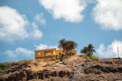 Palm trees and house against sky