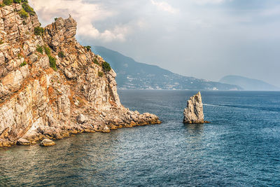 View of rocks in sea against sky