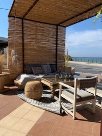 Chairs and table on floor by sea