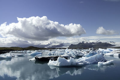 Scenic view of frozen lake against cloudy sky during winter