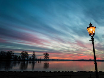 Silhouette street light against sky during sunset
