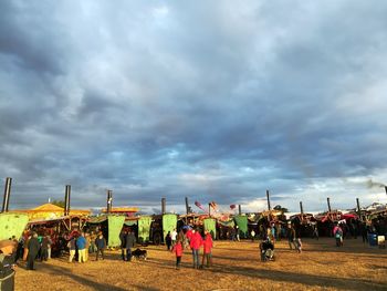 Group of people in stadium against cloudy sky