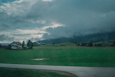 Scenic view of rural landscape against cloudy sky