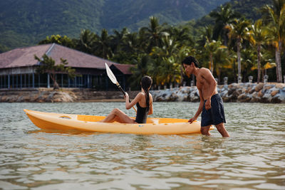 Rear view of man kayaking in lake