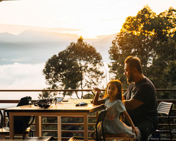 Family having alfresco breakfast during sunrise on the wooden patio.