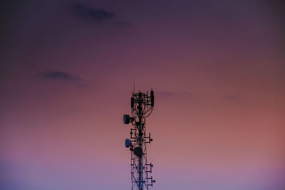 Low angle view of communications tower against sky during sunset