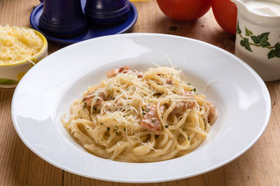 High angle view of spaghetti with carbonara in plate on table