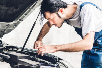 Man repairing car outdoors