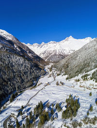 Scenic view of snowcapped mountains against clear blue sky