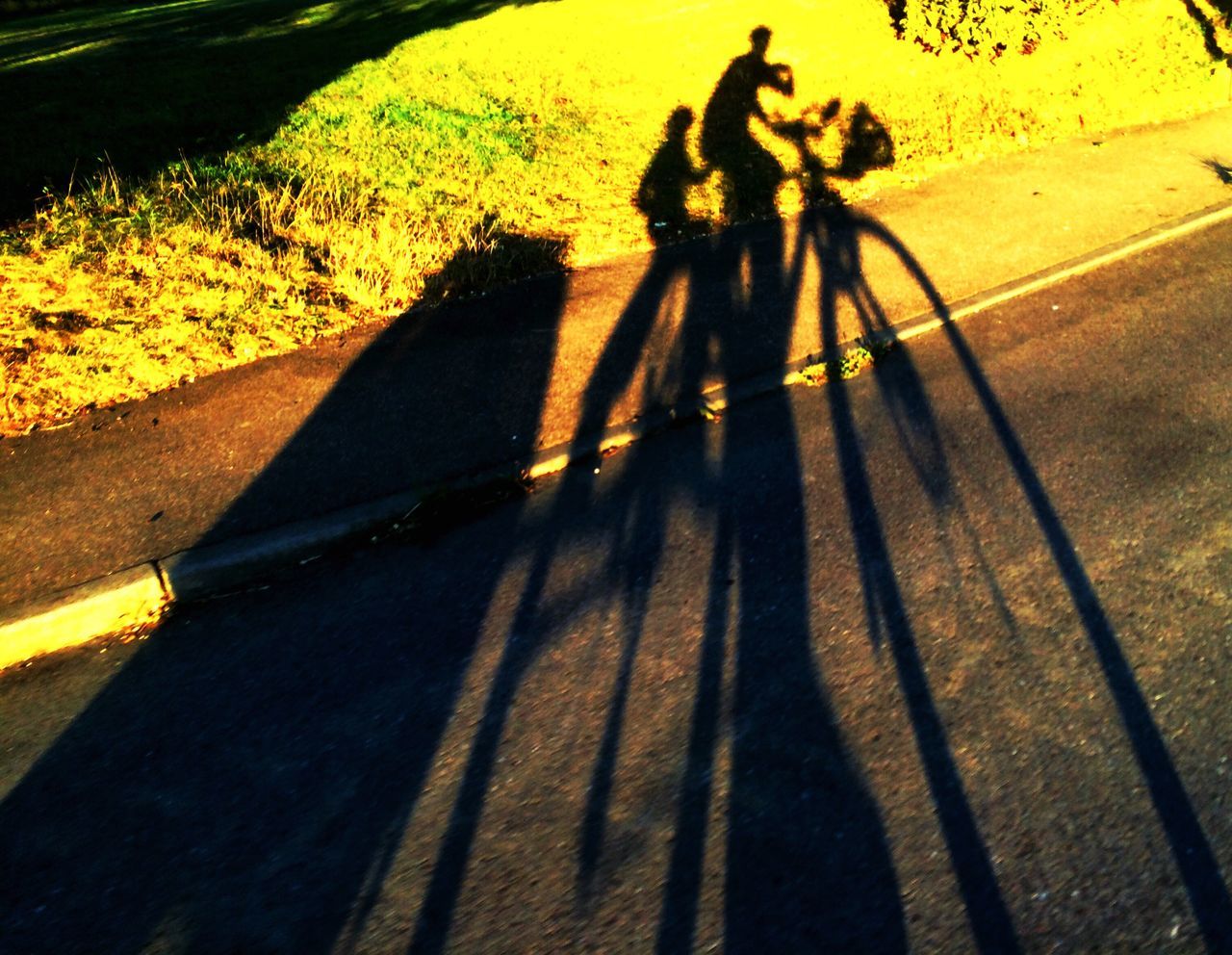 lifestyles, leisure activity, shadow, men, full length, walking, sunlight, high angle view, street, person, togetherness, silhouette, standing, on the move, transportation, road, low section