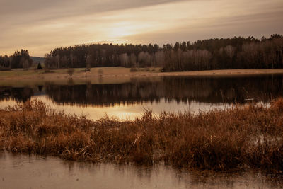 Scenic view of lake against sky at sunset