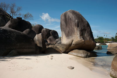 Rocks on beach against sky