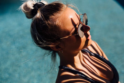 Young woman wearing sunglasses in swimming pool