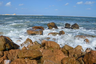 Rocks on beach against sky