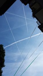 Low angle view of power lines against blue sky