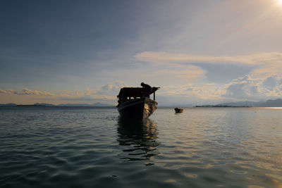 Boat in calm sea against mountain range