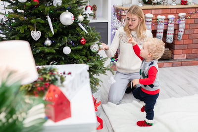 Portrait of smiling woman holding christmas tree