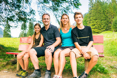 Portrait of a smiling young couple sitting in park