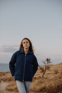 Portrait of smiling young woman standing on land