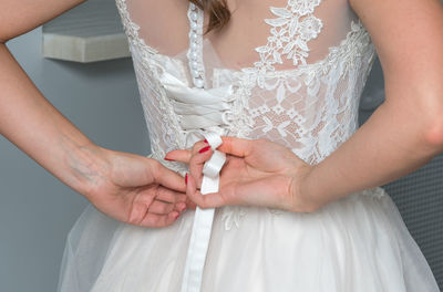 Midsection of bride dressing up during wedding