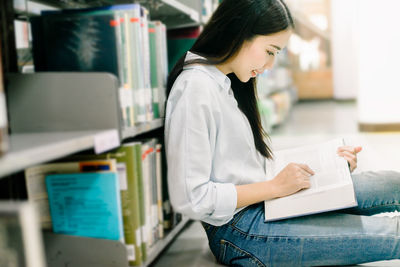 Side view of woman reading book