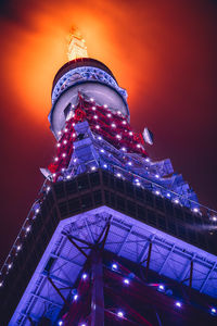 Low angle view of illuminated buildings against sky at night