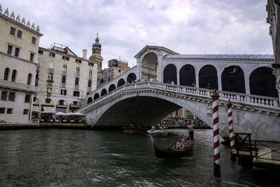 Gondolier and tourists at gondolas in rialto bridge - grand canal 