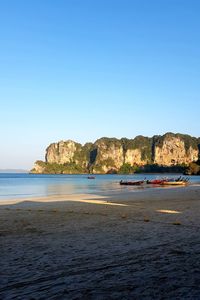 Scenic view of beach against clear blue sky