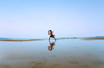 Man standing on beach against sky