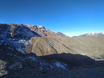 Scenic view of snowcapped mountains against clear blue sky