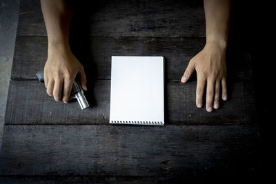 High angle view of woman using mobile phone on table