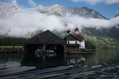 Built structure by lake against sky