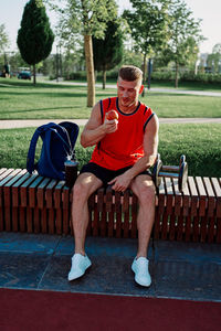 Portrait of young man sitting on bench