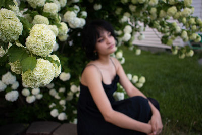 Young woman contemplating by blooming flowers