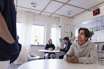 Patients sitting at tables in waiting room