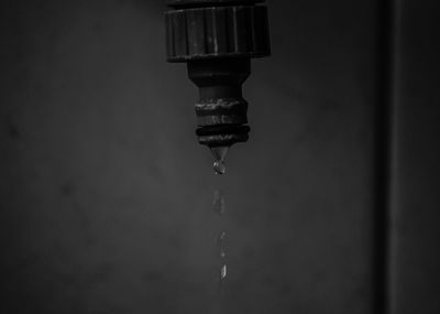 Close-up of water falling from faucet against wall