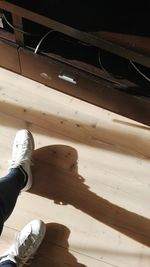 Low section of man standing on hardwood floor