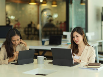 Beautiful businesswomen using computer while sitting in office