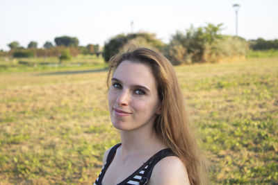 Portrait of young woman on field