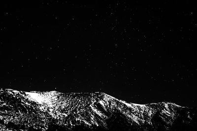 Low angle view of illuminated mountain against sky at night