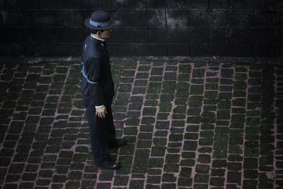 Side view of man standing on footpath at night