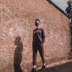 Full length of man standing against wall