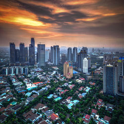 Aerial view of cityscape against cloudy sky