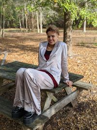 Portrait of smiling young woman sitting on land