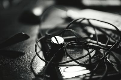 High angle view of in-ear headphones and smart phone on table