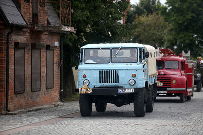 View of cars parked on road by building