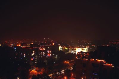 High angle view of illuminated cityscape against sky at night