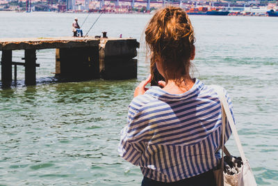 Rear view of woman standing in sea