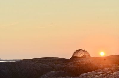 Scenic view of rock against sky during sunset