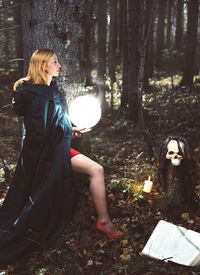 Woman with arms raised in forest